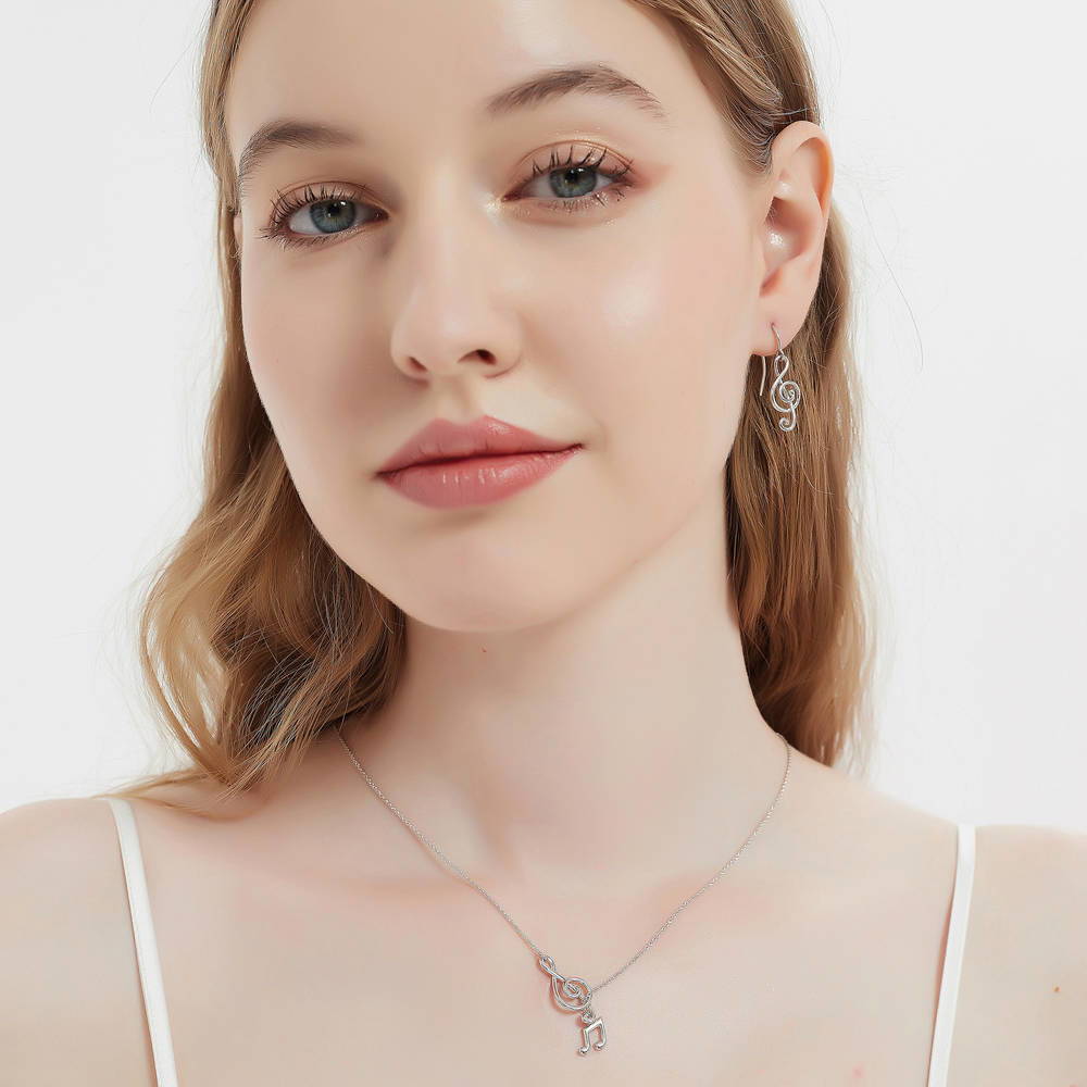 Model wearing Treble Clef Music Note Fish Hook Dangle Earrings in Sterling Silver