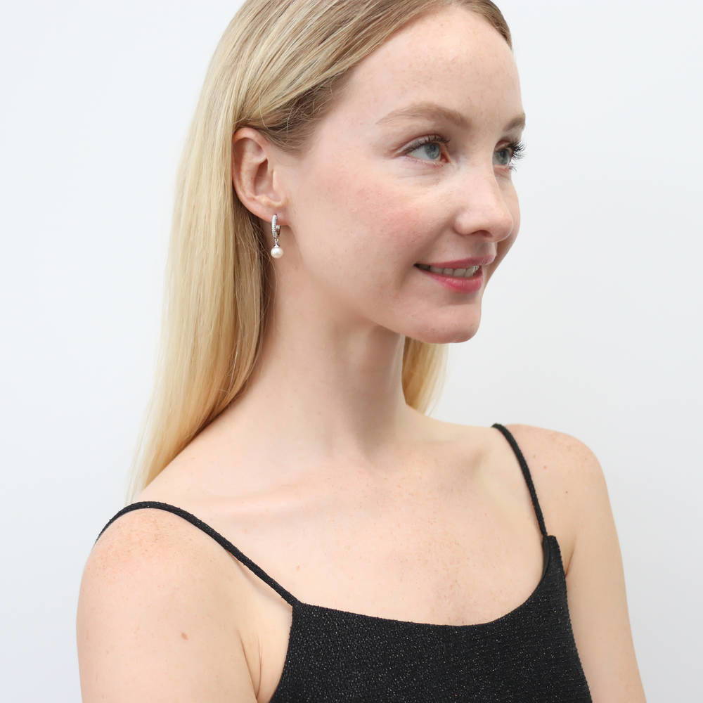 Model wearing Solitaire White Round Cultured Pearl Earrings in Sterling Silver