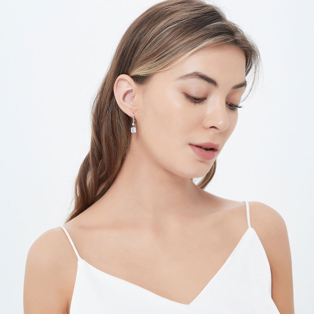 Model wearing Solitaire 4ct Cushion CZ Leverback Dangle Earrings in Sterling Silver, 3 of 5