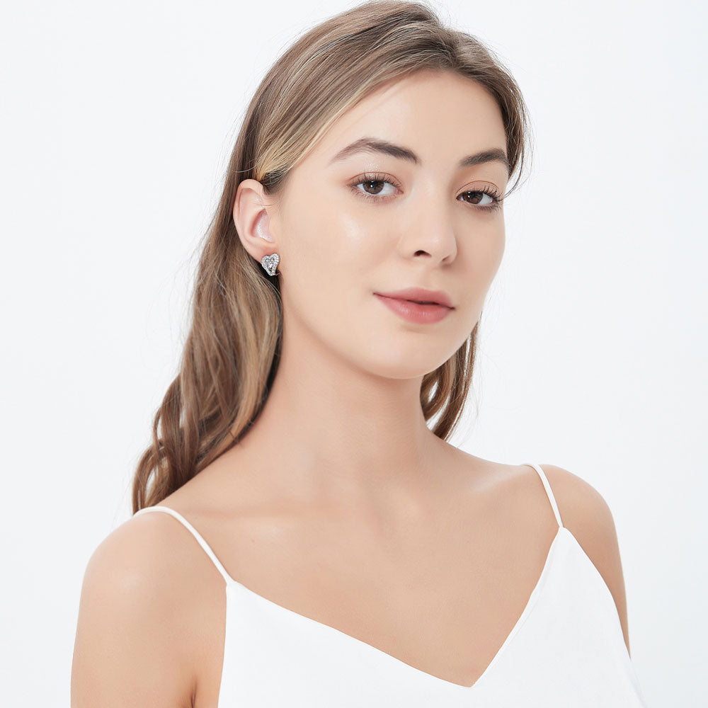 Model wearing Heart Halo CZ Omega Back Stud Earrings in Sterling Silver