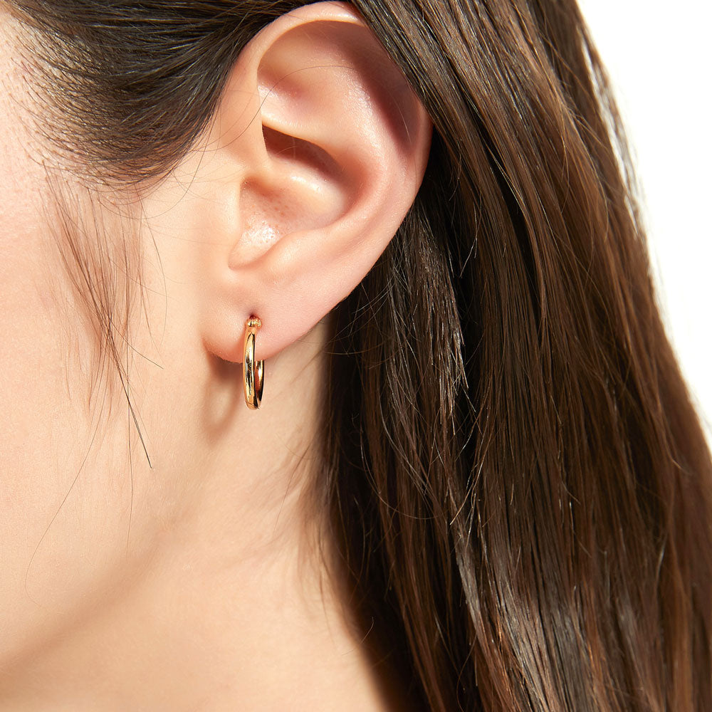 Model wearing Small Hoop Earrings in Sterling Silver 0.6 inch, Yellow Gold Flashed