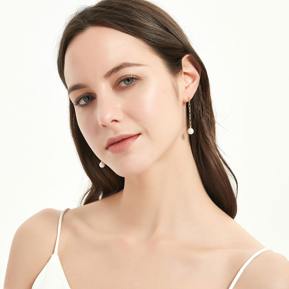 Model wearing Solitaire White Oval Cultured Pearl Earrings in Sterling Silver