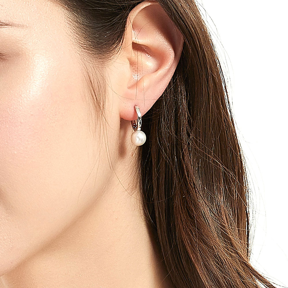 Model wearing Solitaire Round Cultured Pearl Huggie Earrings in Sterling Silver 0.8 inch