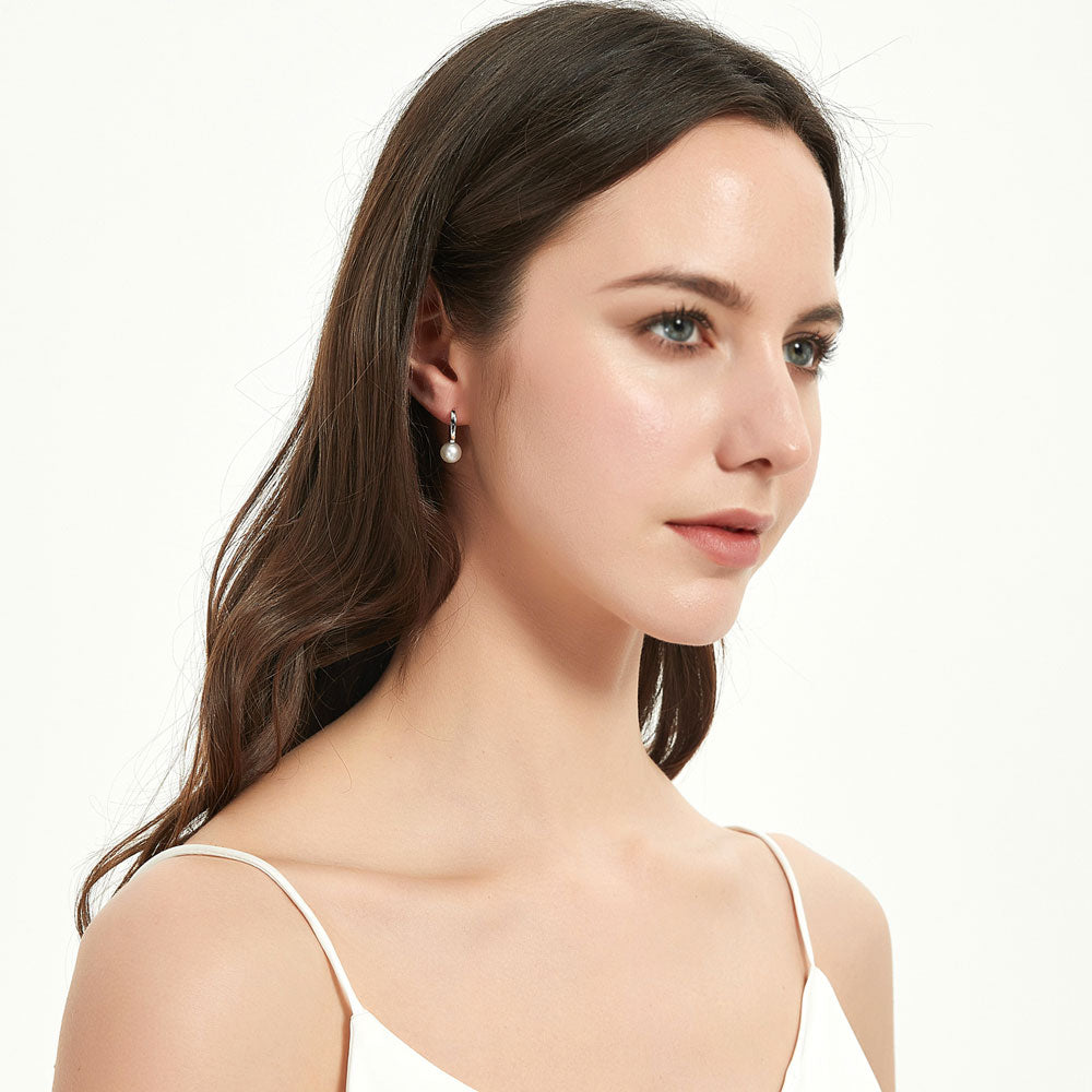 Model wearing Solitaire Round Cultured Pearl Huggie Earrings in Sterling Silver 0.8 inch