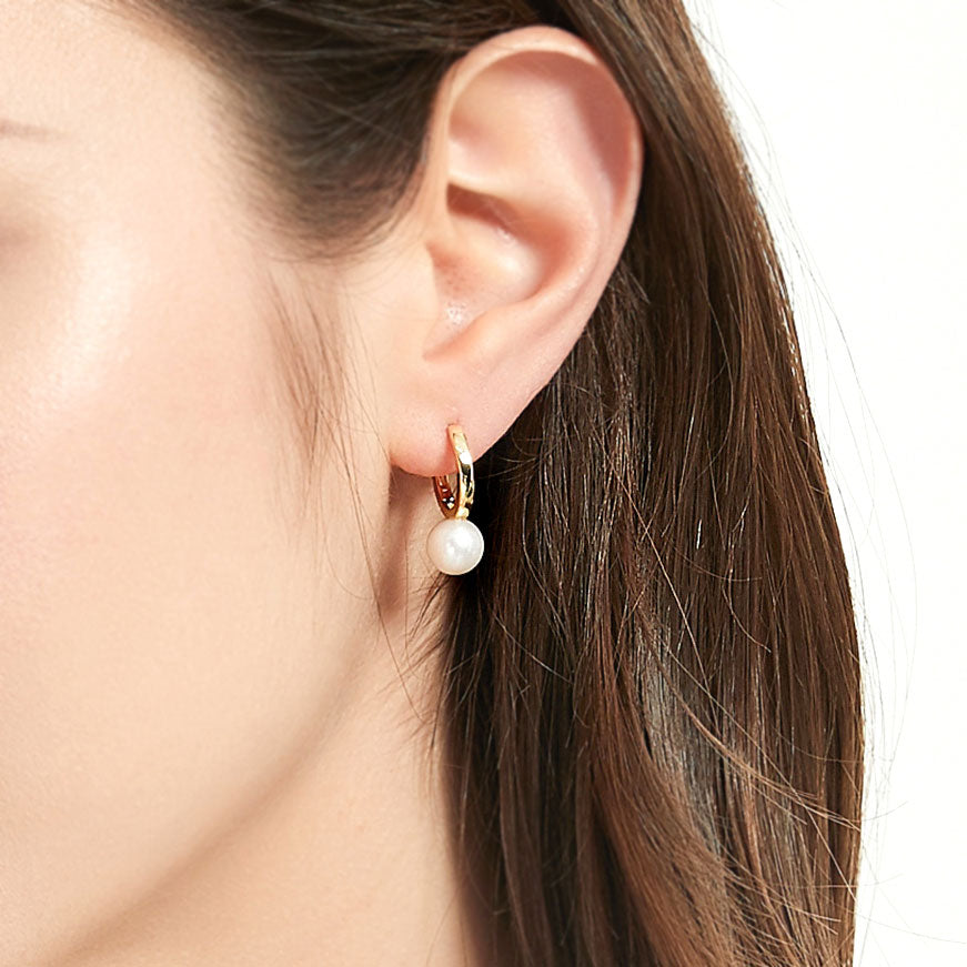 Model wearing Solitaire Round Cultured Pearl Huggie Earrings in Sterling Silver 0.8 inch