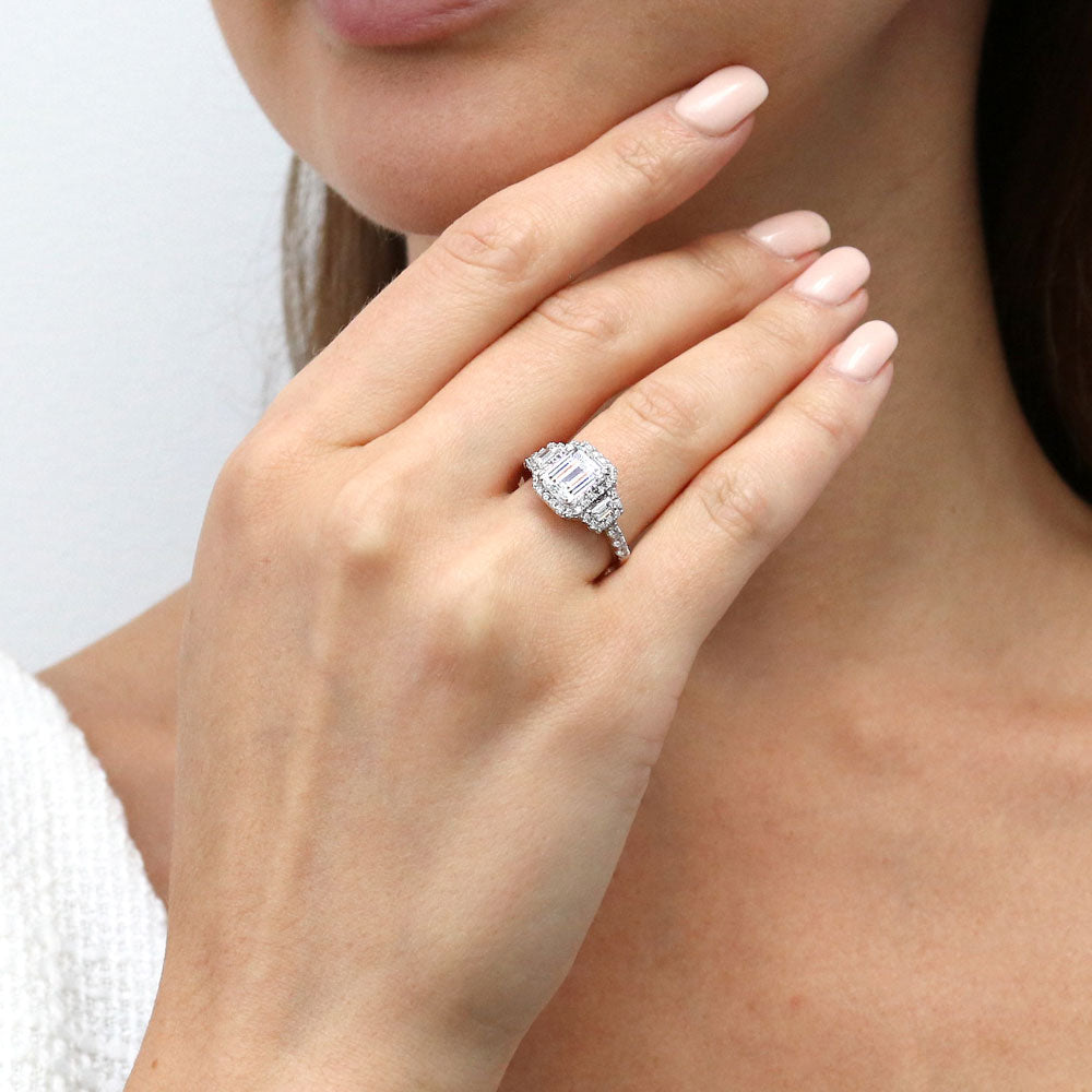 Model wearing 3-Stone Halo Step Emerald Cut CZ Ring in Sterling Silver