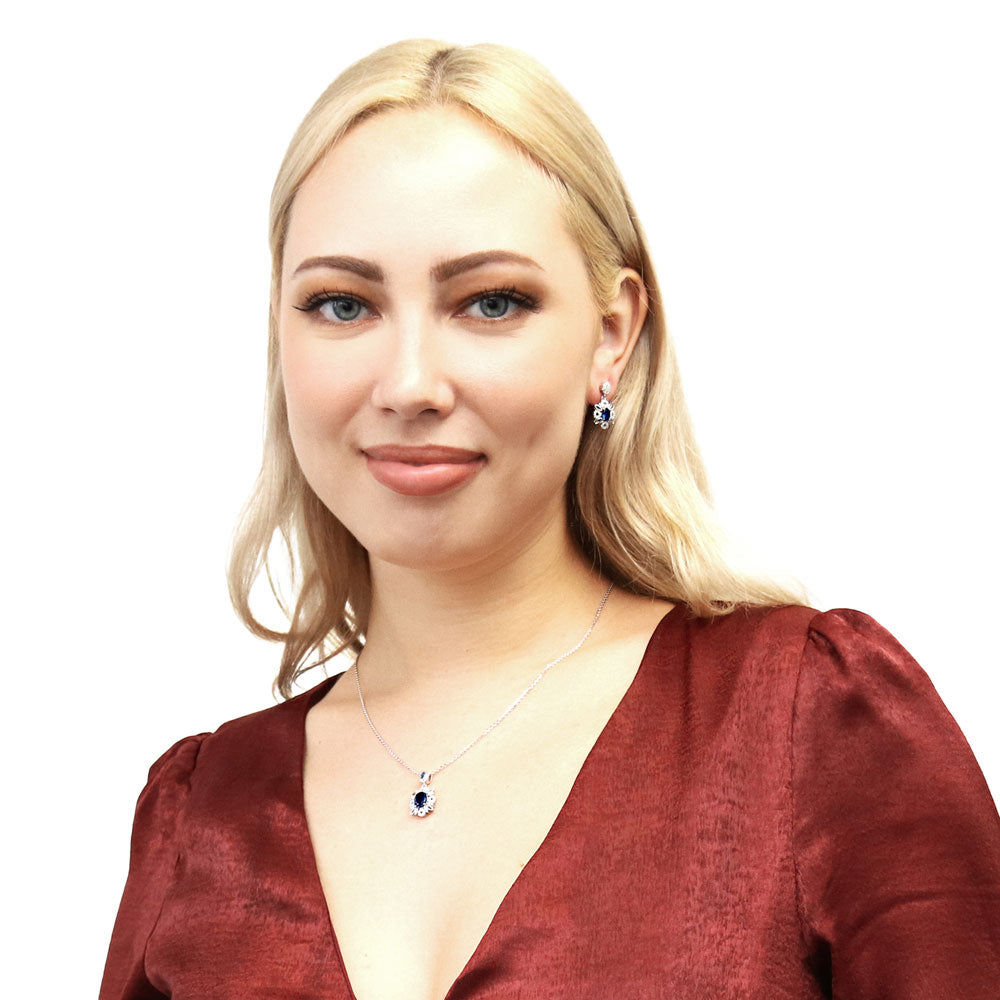 Model wearing Flower Halo Simulated Blue Sapphire CZ Earrings in Sterling Silver