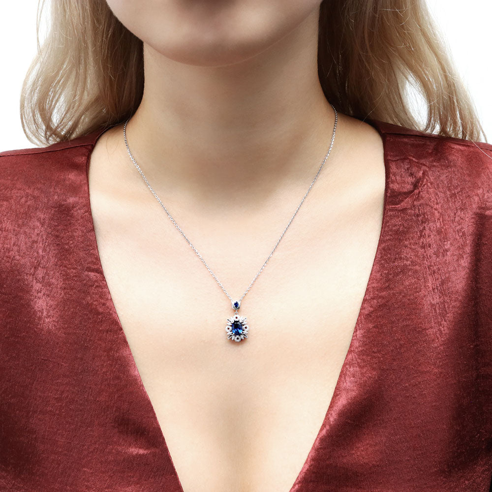 Model wearing Flower Halo Simulated Blue Sapphire CZ Necklace in Sterling Silver