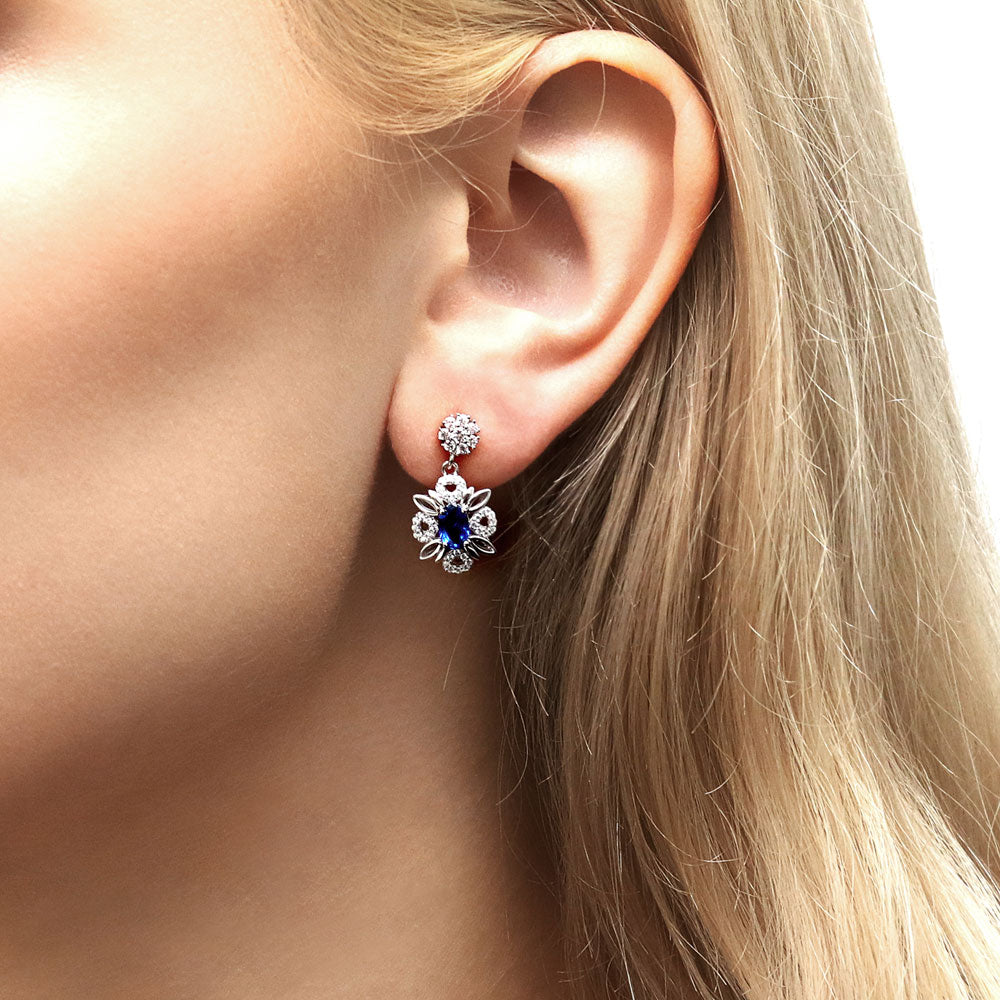 Model wearing Flower Halo Simulated Blue Sapphire CZ Earrings in Sterling Silver