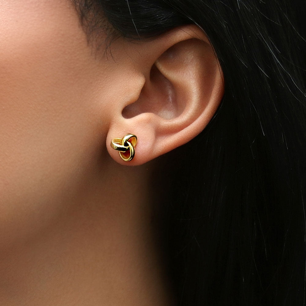 Model wearing Love Knot Stud Earrings in Sterling Silver, Yellow Gold Flashed