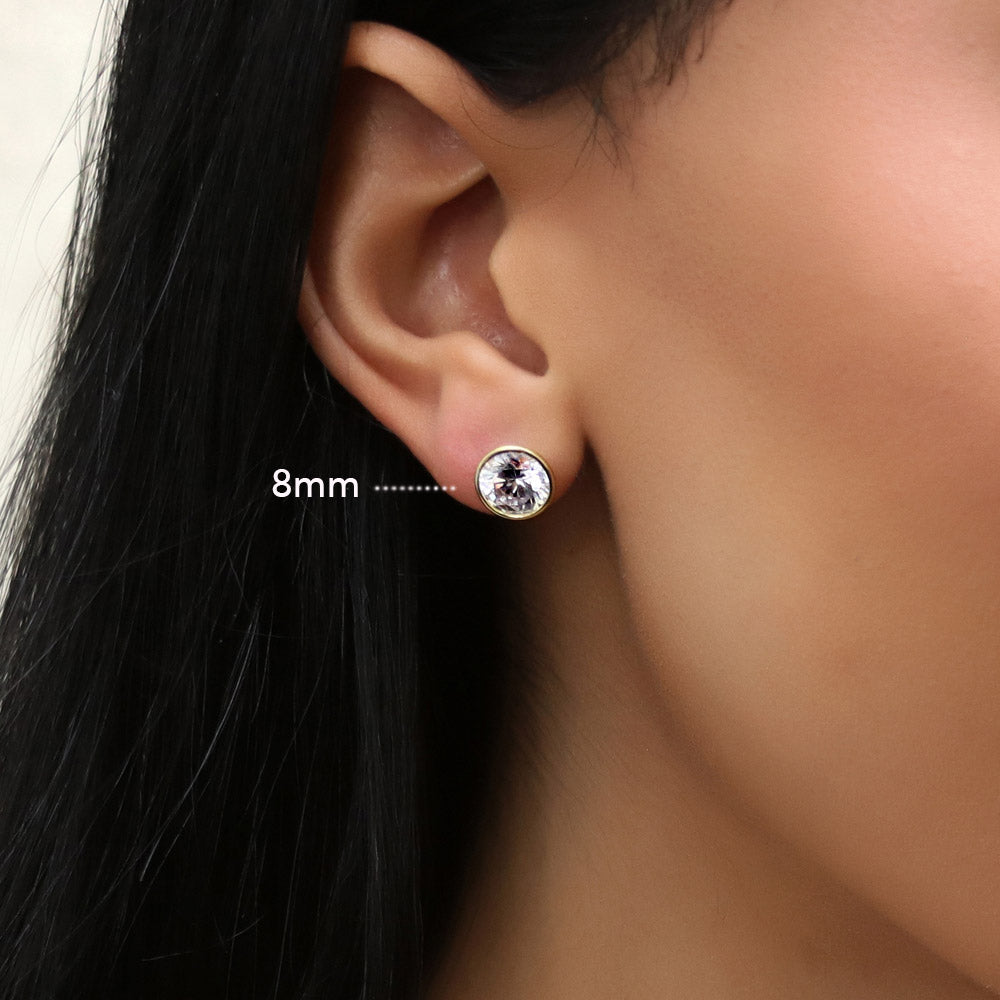 Model wearing Solitaire Bezel Set Round CZ Stud Earrings in Sterling Silver