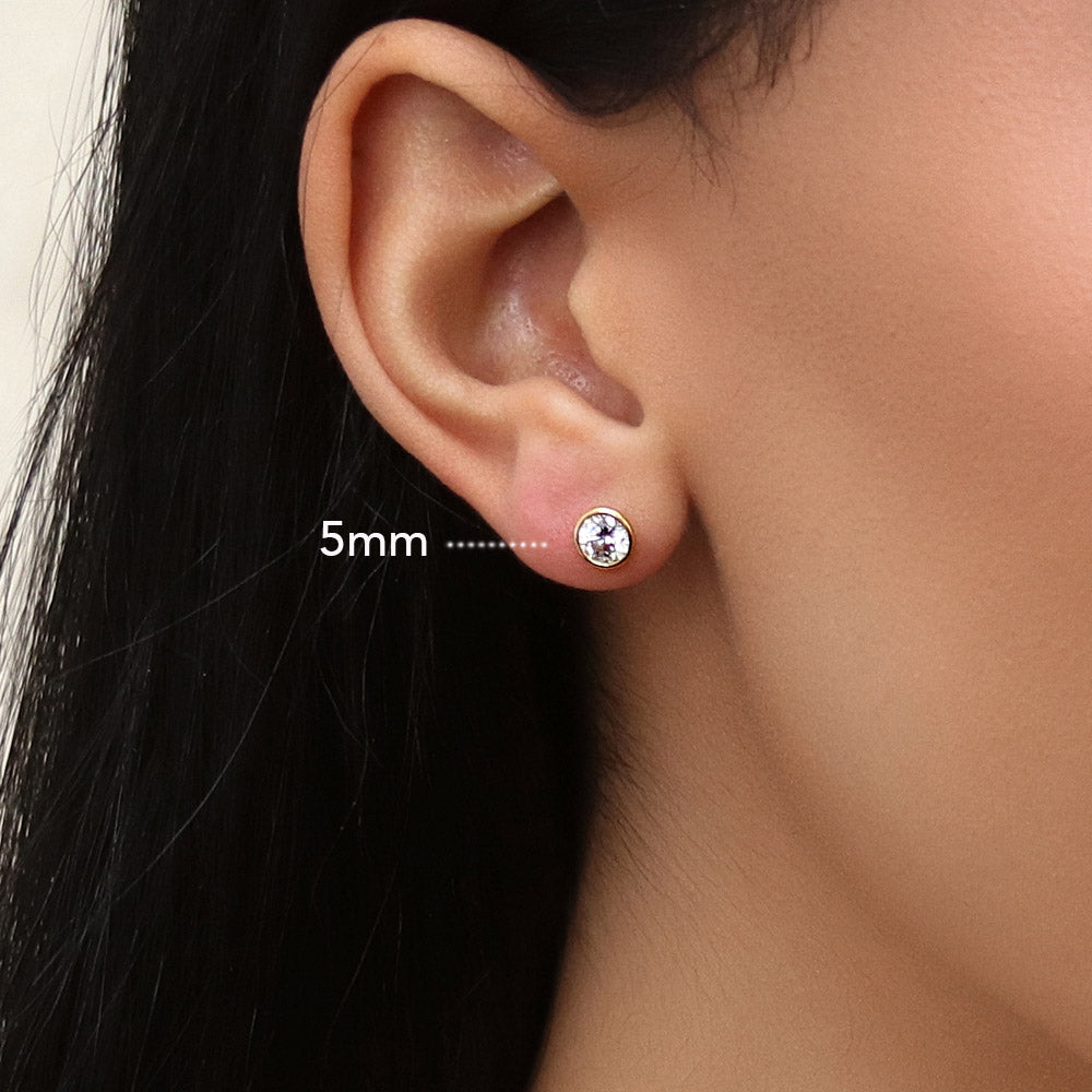 Model wearing Solitaire Bezel Set Round CZ Stud Earrings in Sterling Silver