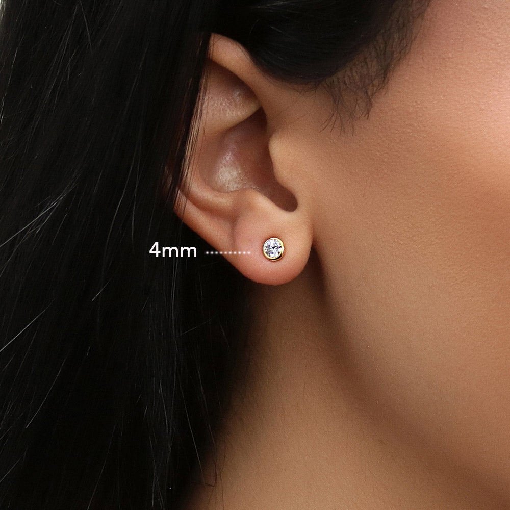 Model wearing Solitaire Bezel Set Round CZ Stud Earrings in Sterling Silver