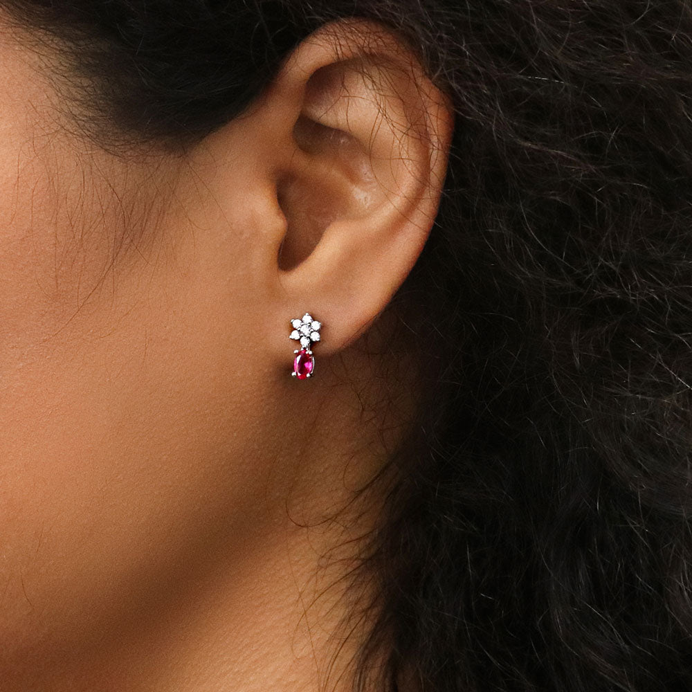 Model wearing Flower Simulated Ruby CZ Stud Earrings in Sterling Silver