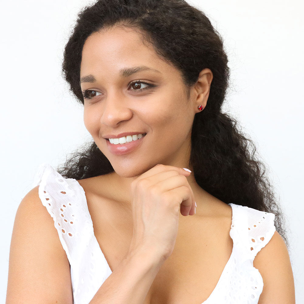 Model wearing Solitaire 1.6ct CZ Cartilage Stud Earrings in Sterling Silver, Garnet Color