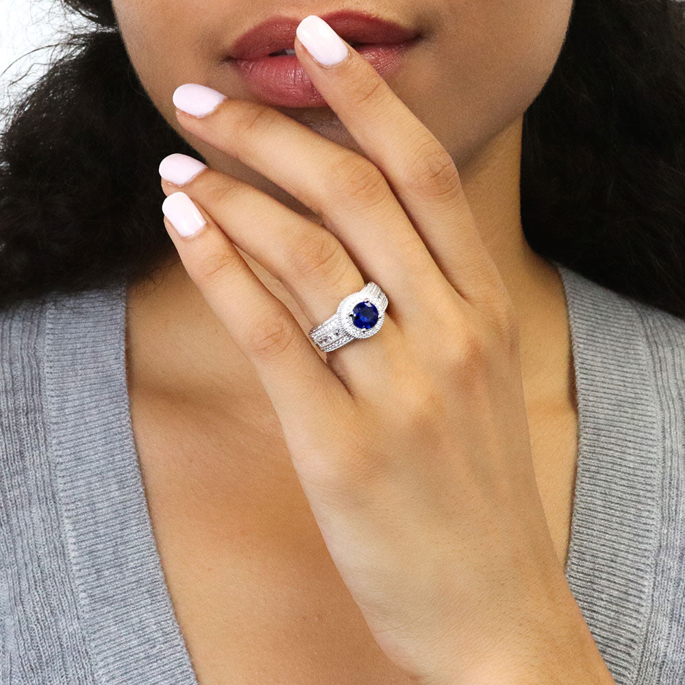 Model wearing Halo Milgrain Simulated Blue Sapphire Round CZ Ring in Sterling Silver