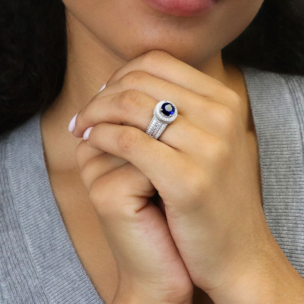 Model wearing Halo Milgrain Simulated Blue Sapphire Round CZ Ring in Sterling Silver