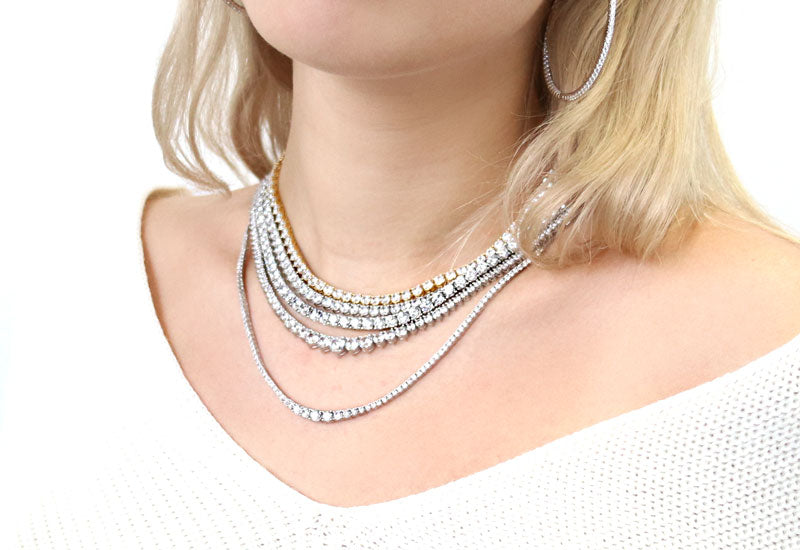 Model wearing multiple tennis necklaces