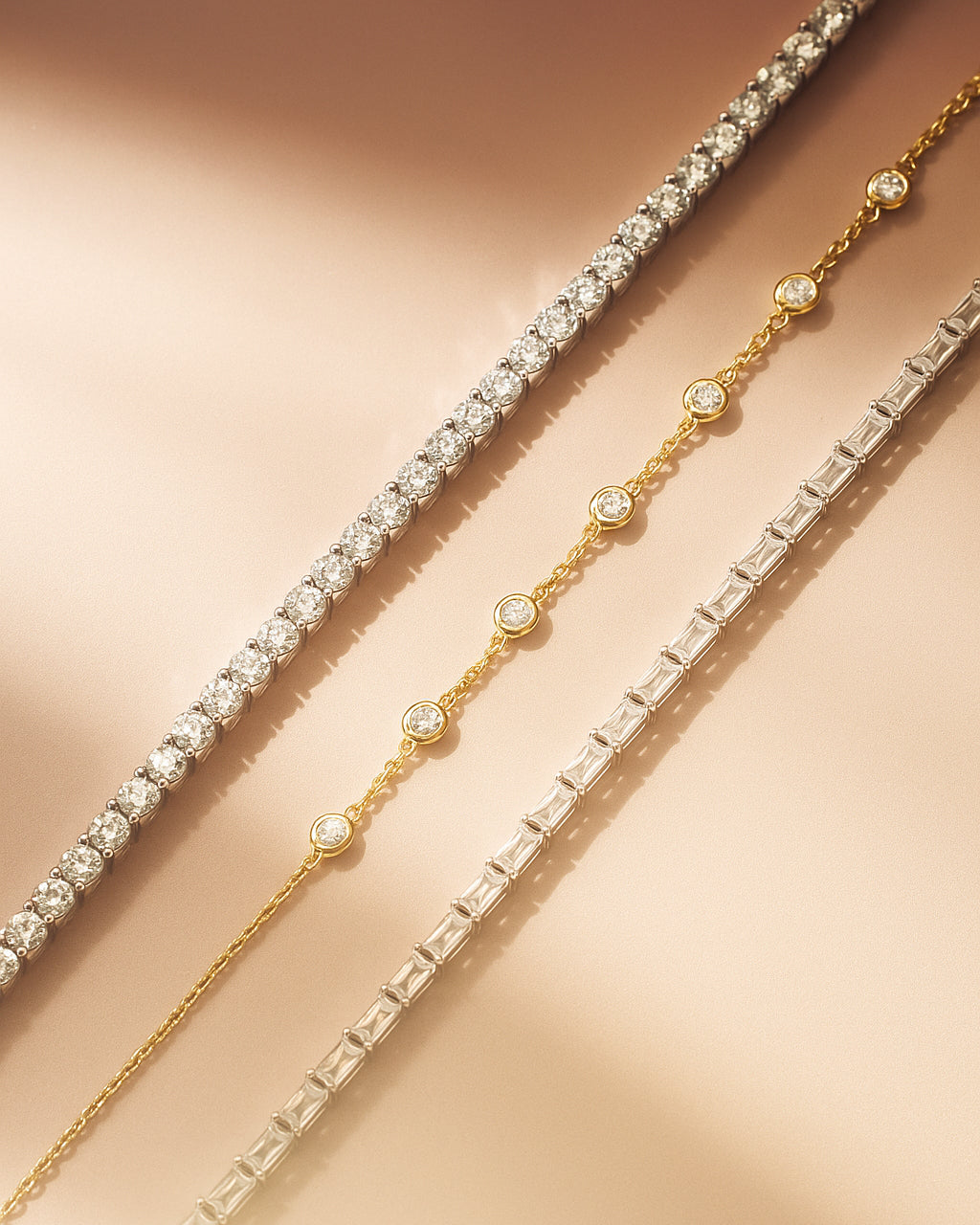 Three bracelets with clear stones on a beige background