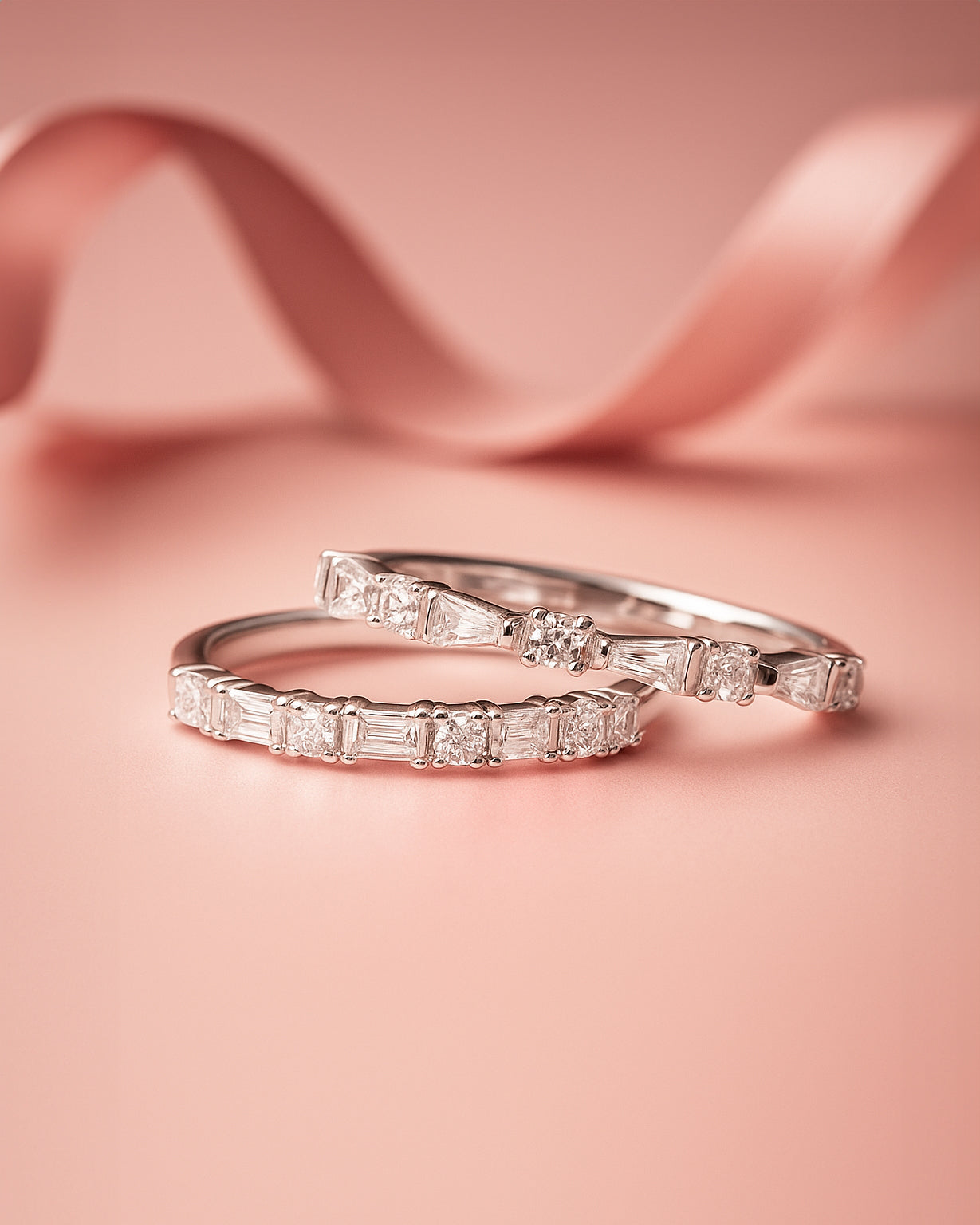Two rings on a pink ribbon background