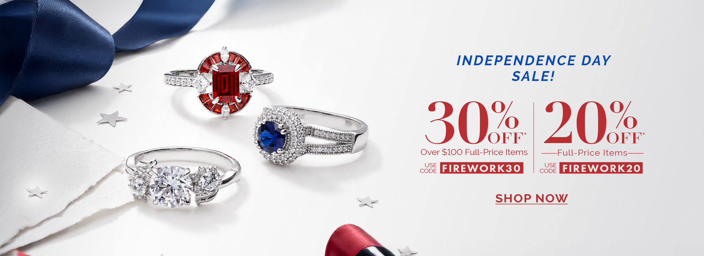 An Independence Day sale banner featuring three silver rings with red, white, and blue stones on a white background. Text on the right announces a sale: "30% OFF Over $100 Full-Price Items" with code "FIREWORK30", and "20% OFF Full-Price Items" with code "FIREWORK20".