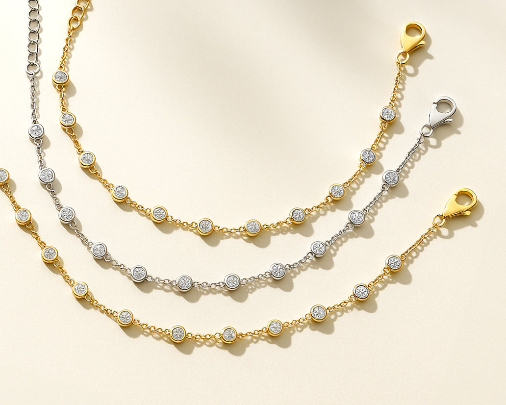 Three bracelets with CZ stones on a beige background