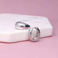 Flatlay view of Oval Dome Small Huggie Earrings in Sterling Silver 0.6 inch, Yellow Gold Flashed