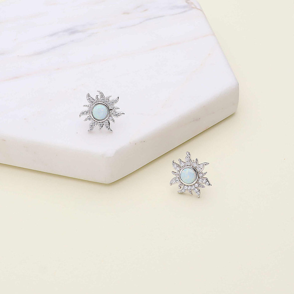 Flatlay view of Sun Sunburst Halo Opal-White CZ Stud Earrings in Sterling Silver, Yellow Gold Flashed