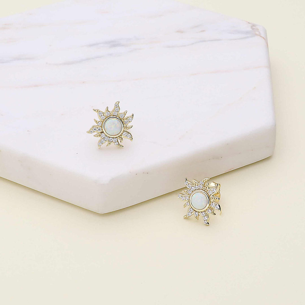 Flatlay view of Sun Sunburst Halo Opal-White CZ Stud Earrings in Sterling Silver, Yellow Gold Flashed
