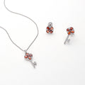 Flatlay view of Key and Lock CZ Stud Earrings in Sterling Silver, Red Color