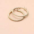Flatlay view of Cable Hoop Earrings in Sterling Silver 1.2 inch, Yellow Gold Flashed
