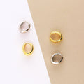 Flatlay view of Oval Dome Small Huggie Earrings in Sterling Silver 0.6 inch