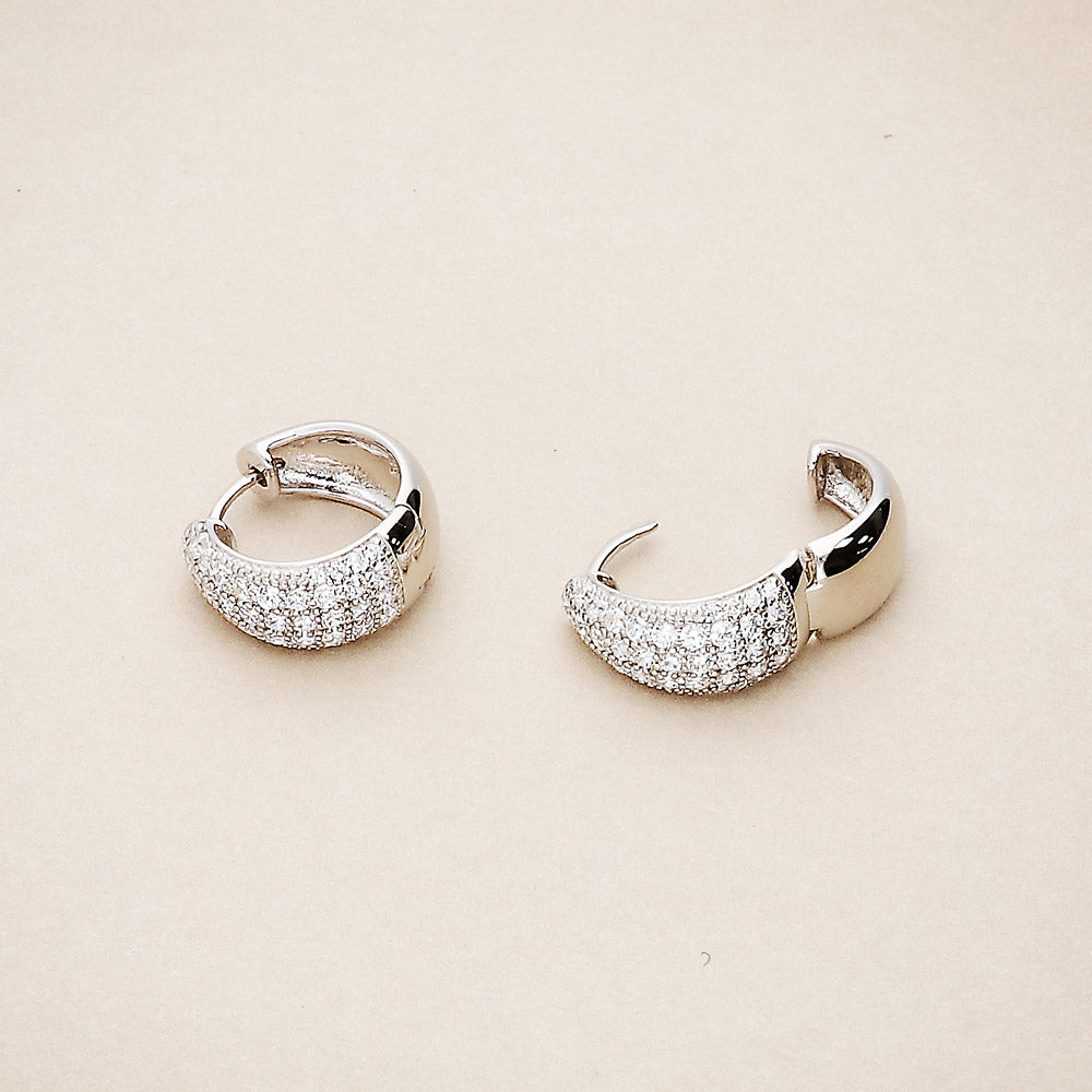 Flatlay view of Dome CZ Small Huggie Earrings in Sterling Silver 0.6 inch, Rhodium Plated, Cubic Zirconia