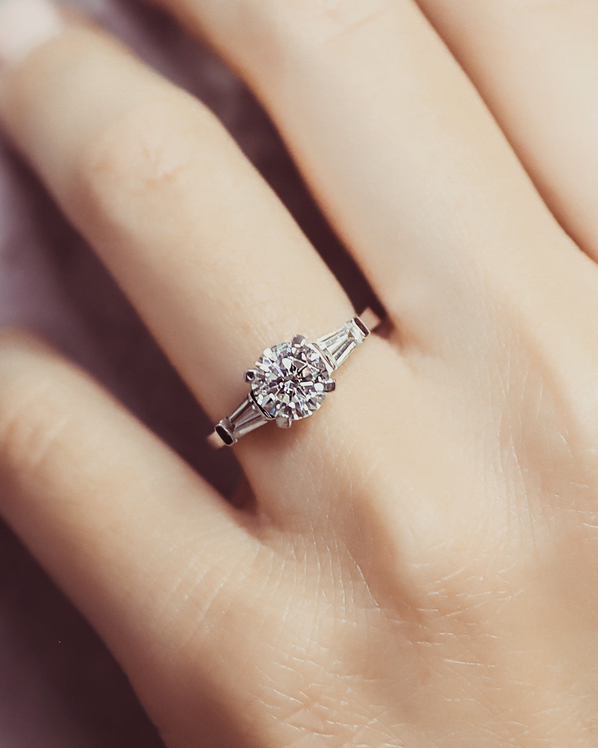 round engagement ring on a finger