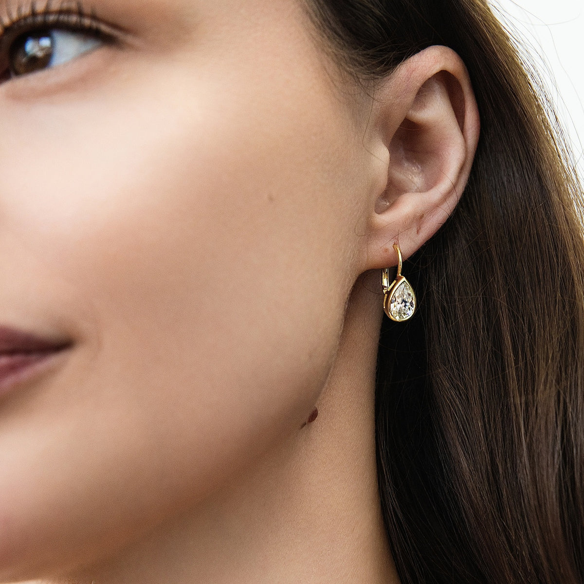 Model wearing Solitaire 2.6ct Pear CZ Leverback Earrings in Sterling Silver, Gold Flashed