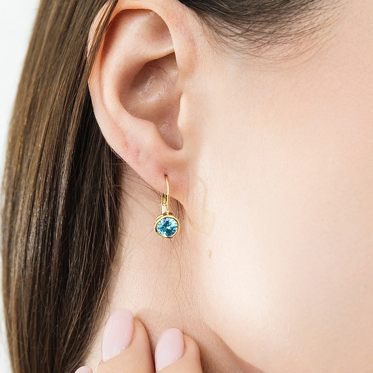 Model wearing Solitaire 1.2ct Bezel CZ Earrings in Sterling Silver, Aquamarine, Gold Plated