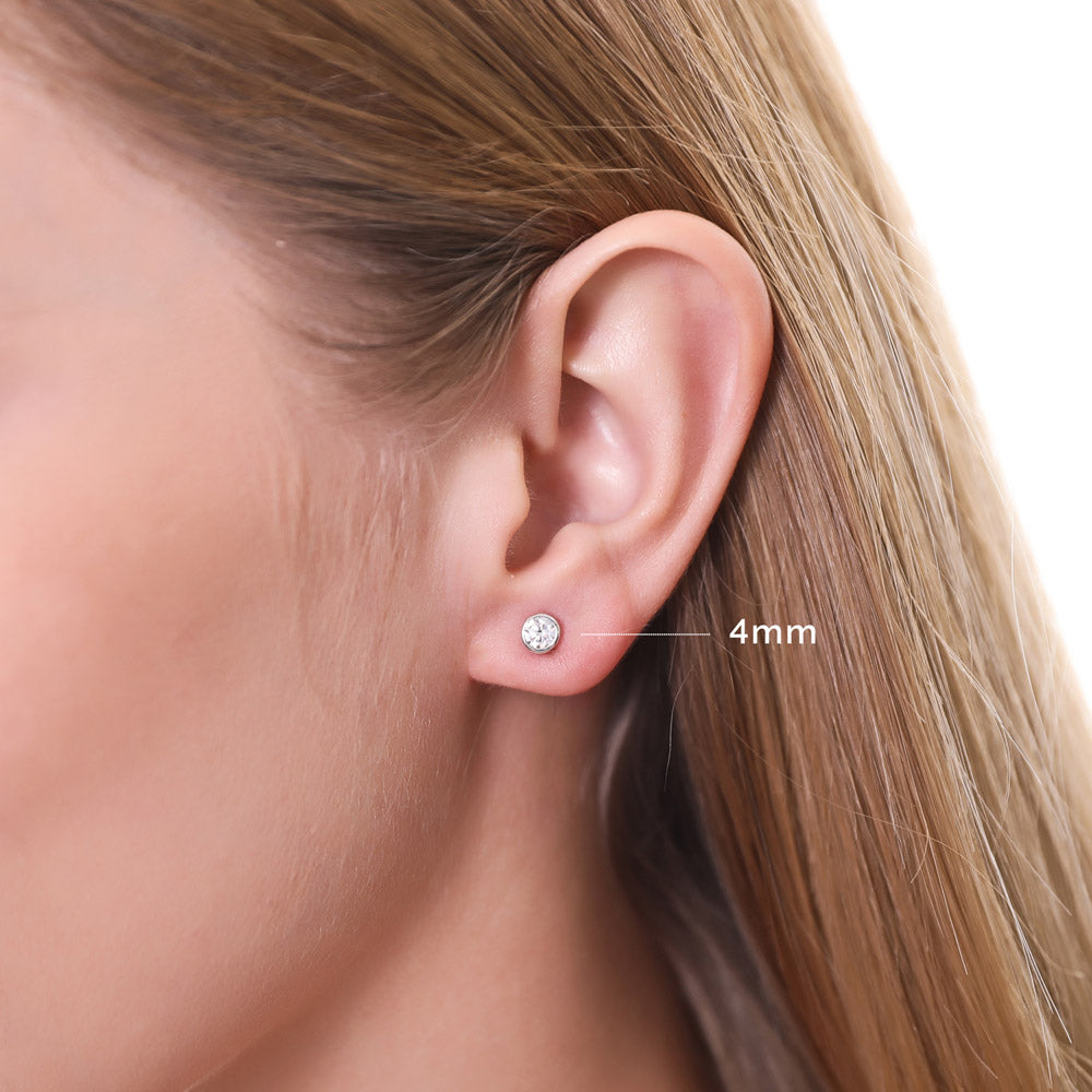 Model wearing Solitaire Bezel CZ Stud Earrings in Gold Flashed Sterling Silver, Rhodium Plated, Clear / 4mm