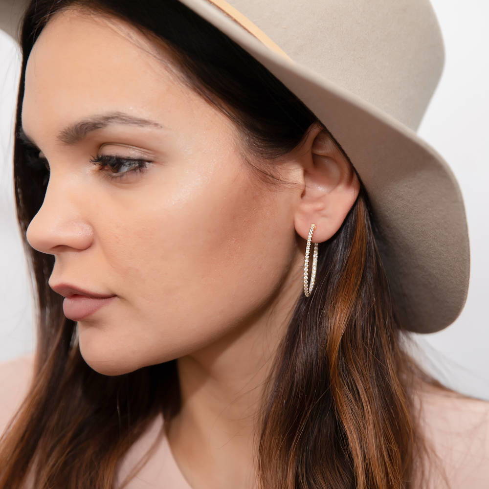 Model wearing Oval CZ Inside-Out Hoop Earrings in Sterling Silver 1.4 inch, Yellow Gold Flashed