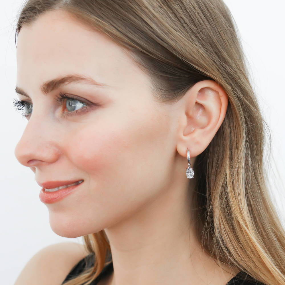Model wearing Solitaire CZ Cartilage Huggie Earrings in Sterling Silver 0.5 inch, Oval Cut