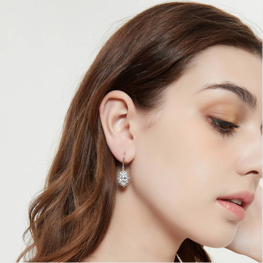 Model wearing Solitaire Filigree Oval CZ Fish Hook Earrings in Sterling Silver, 5 of 8