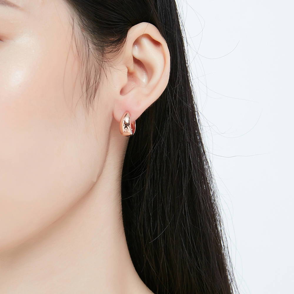 Model wearing Dome CZ Small Huggie Earrings in Sterling Silver 0.6 inch, Rose Gold Flashed