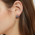 Model wearing Halo Kaleidoscope CZ Stud Earrings in Sterling Silver, Purple Aqua