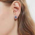 Model wearing Halo Kaleidoscope CZ Stud Earrings in Sterling Silver, Purple Aqua