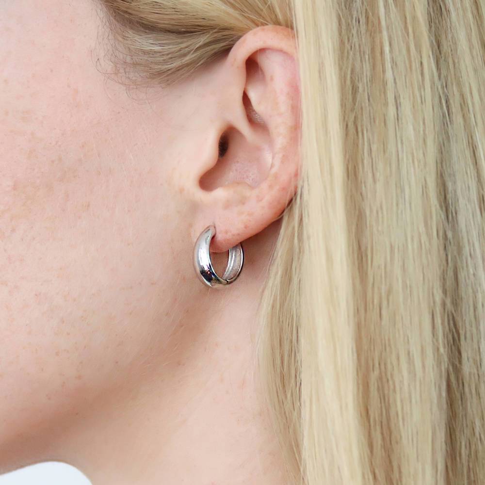 Model wearing Oval Dome Small Huggie Earrings in Sterling Silver 0.6 inch, Yellow Gold Flashed