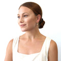 Model wearing Solitaire CZ Cartilage Huggie Earrings in Sterling Silver 0.5 inch, Round Cut, Gold Flashed