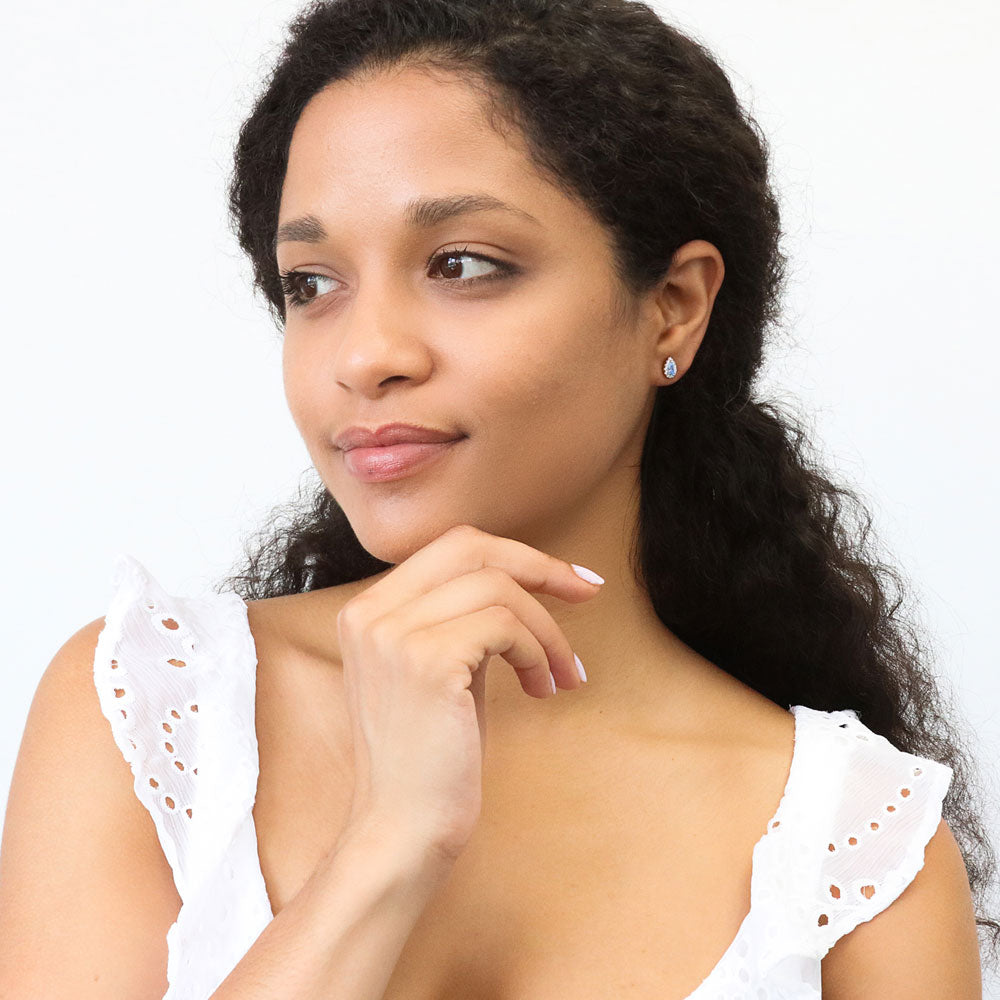 Model wearing Halo Pear CZ Stud Earrings in Sterling Silver, Green Color