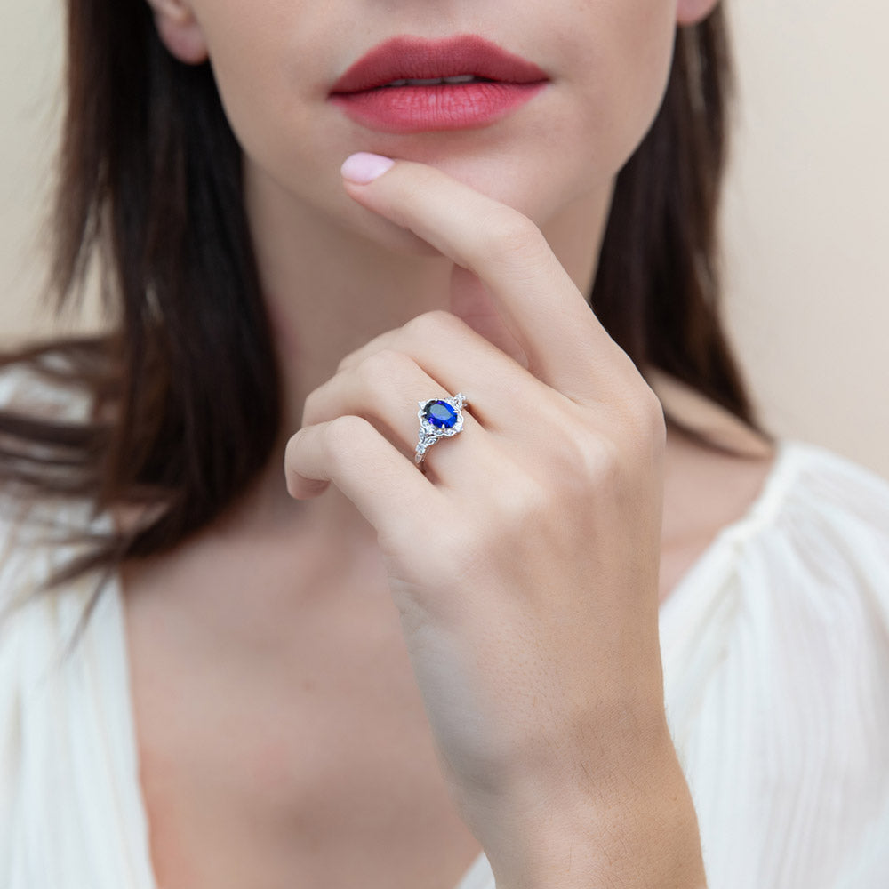 Model wearing Halo Art Deco Simulated Blue Sapphire Oval CZ Ring in Sterling Silver, 3 of 10