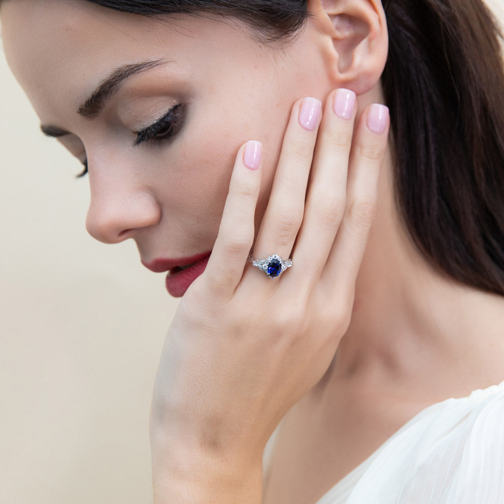 Model wearing Halo Art Deco Simulated Blue Sapphire Oval CZ Ring in Sterling Silver, 2 of 10