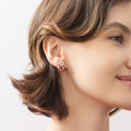 Model wearing Key and Lock CZ Stud Earrings in Sterling Silver, Red Color