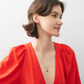 Model wearing Solitaire 1ct Pear CZ Necklace in Sterling Silver, Garnet Color